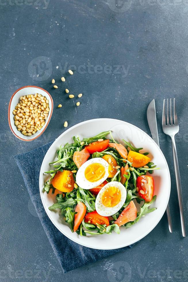 Mittagssalat in weißer Platte auf blauem Hintergrund. draufsicht, gesundes lebensmittelkonzept foto