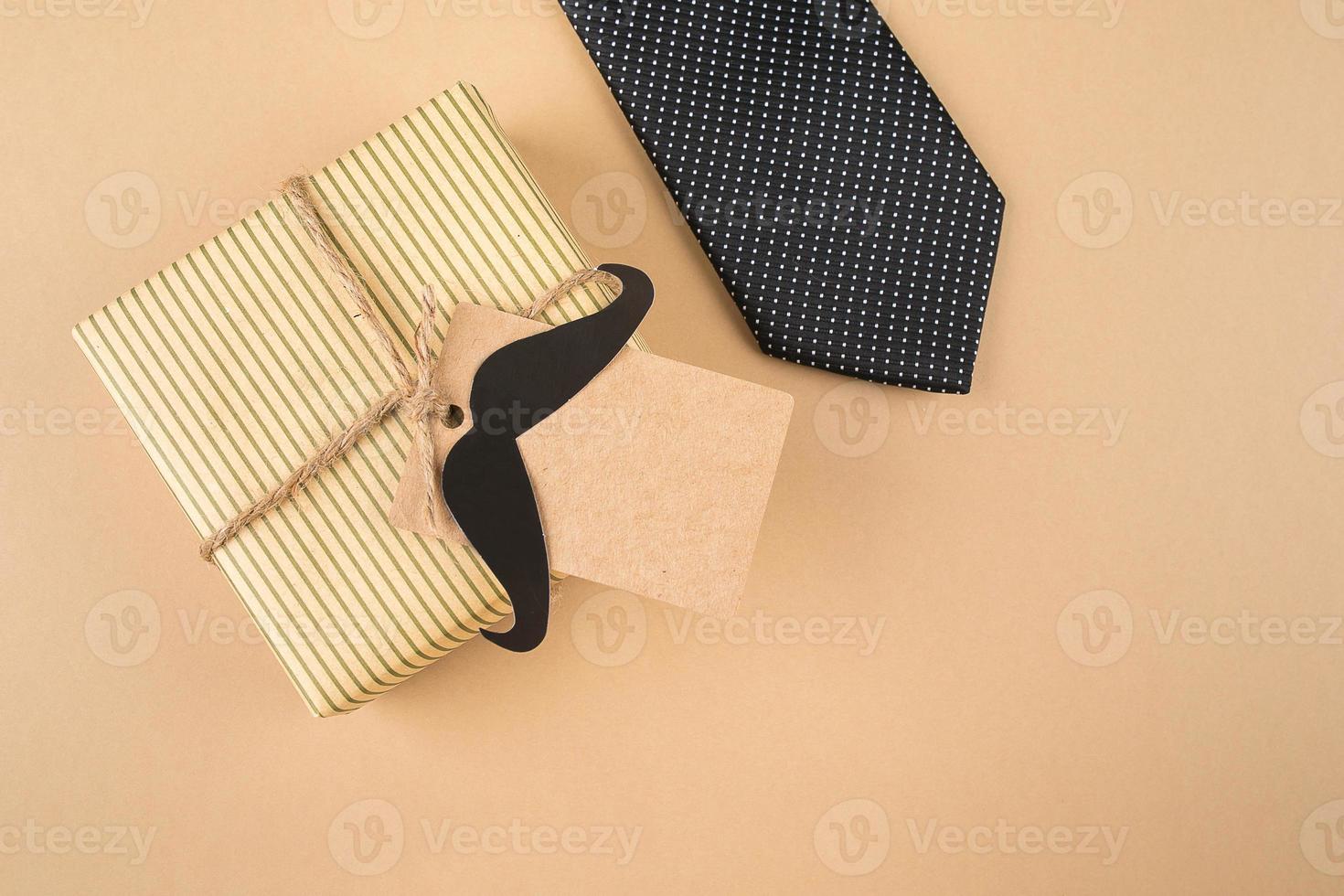 Geschenkbox mit Tag, Krawatte auf neutralem Hintergrund. draufsicht, kopierraum, flache lage. vatertagskonzept foto