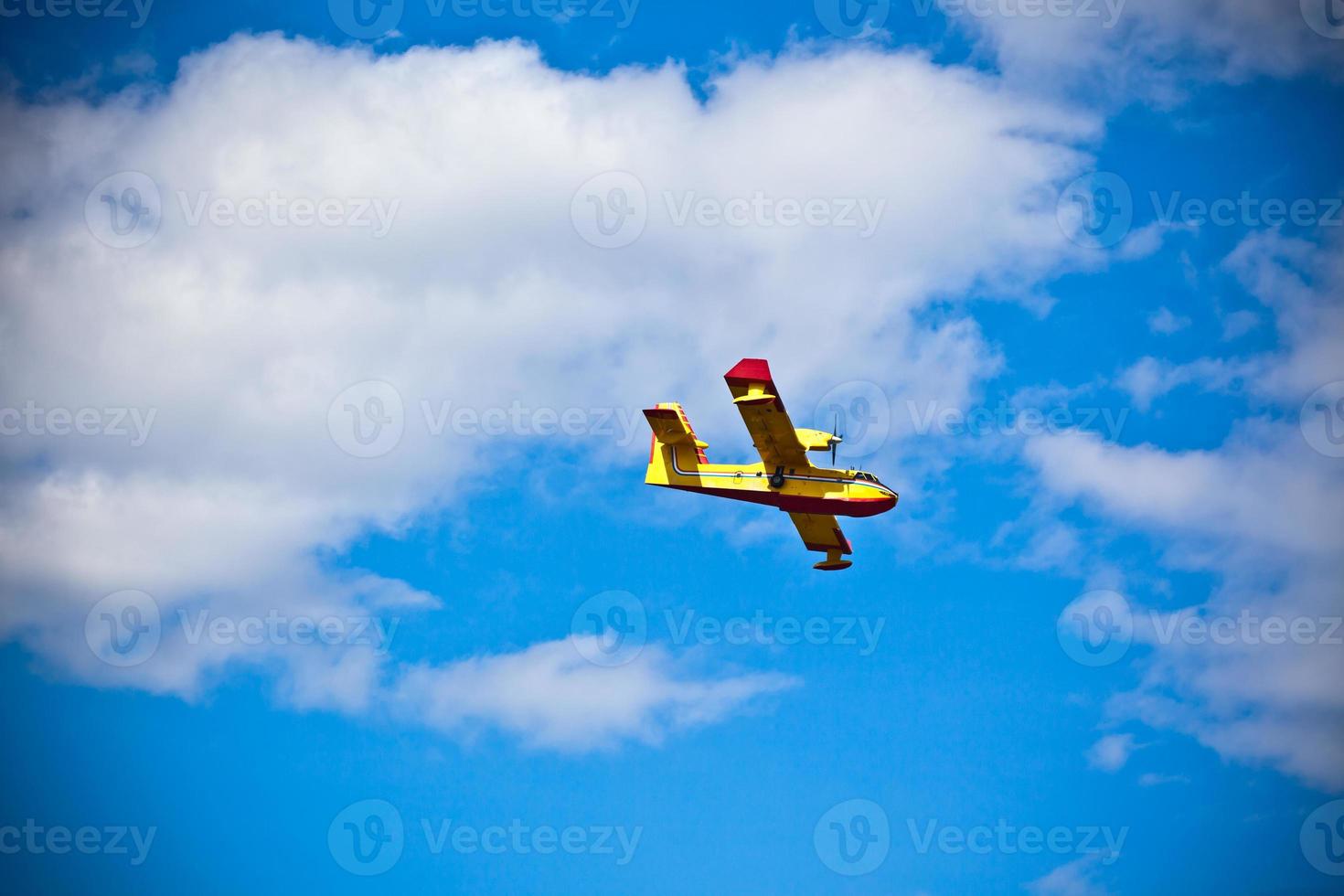 leuchtend gelbes Feuerwehrflugzeug in einem blauen Himmel foto