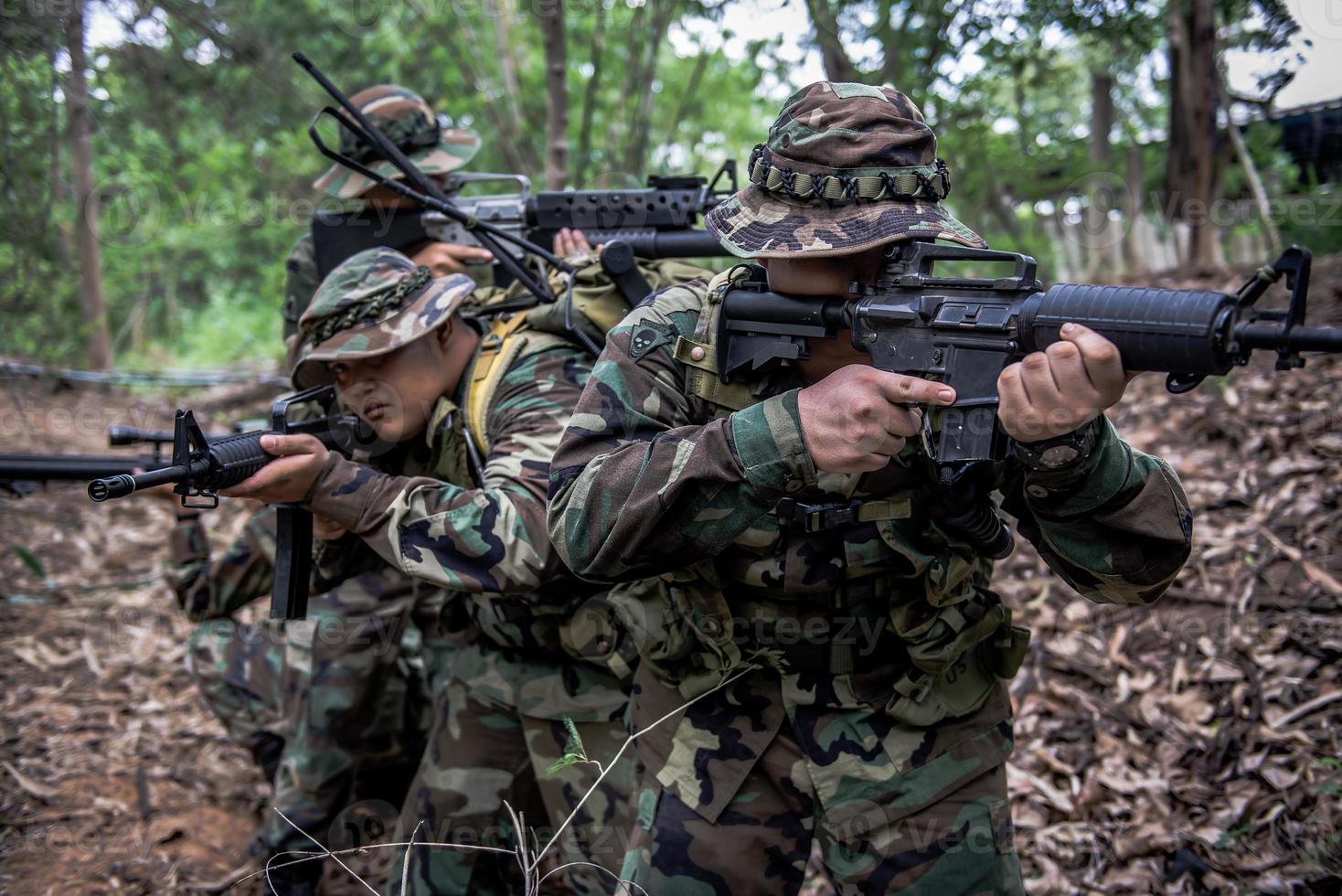 ein team von soldaten der armee mit maschinengewehr bewegt sich im wald, thailändischer milizsoldat in kampfuniformen im wald, wandert die patrouille durch den regenwald. foto