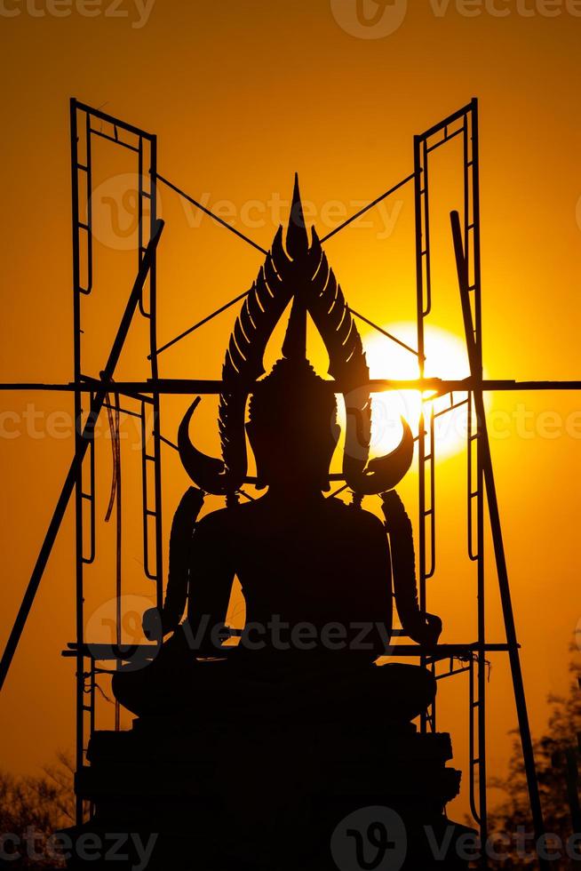 silhouette buddha-statue zwischen dem herstellungs- und bauprozess, auf einem feld im freien mit sonnenuntergang und dämmerungszeit., thailand. foto