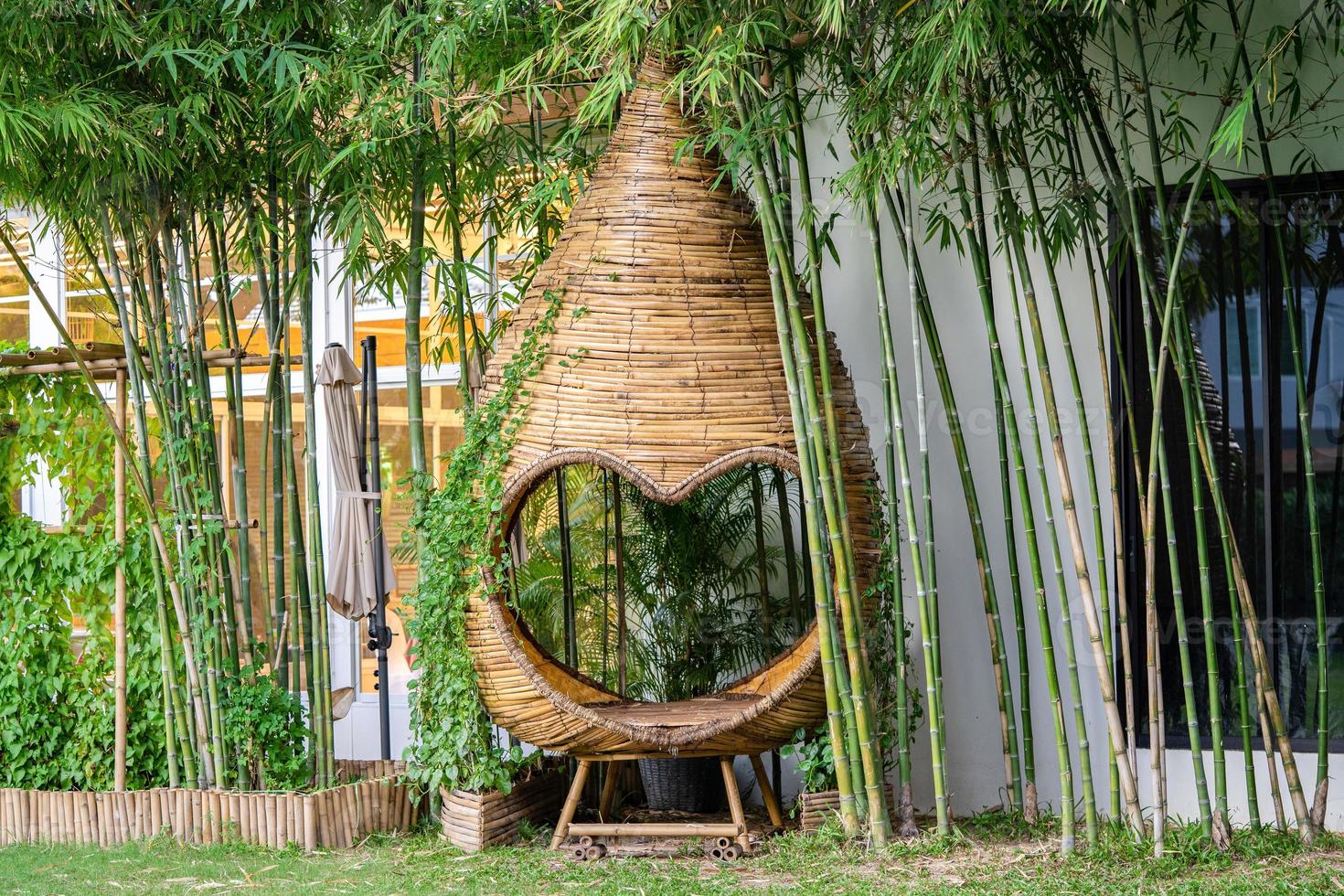 Herzform und Kokon-Mini-Pavillon-Relaxzone im Garten, Weidengeflecht mit Bambusstab. foto