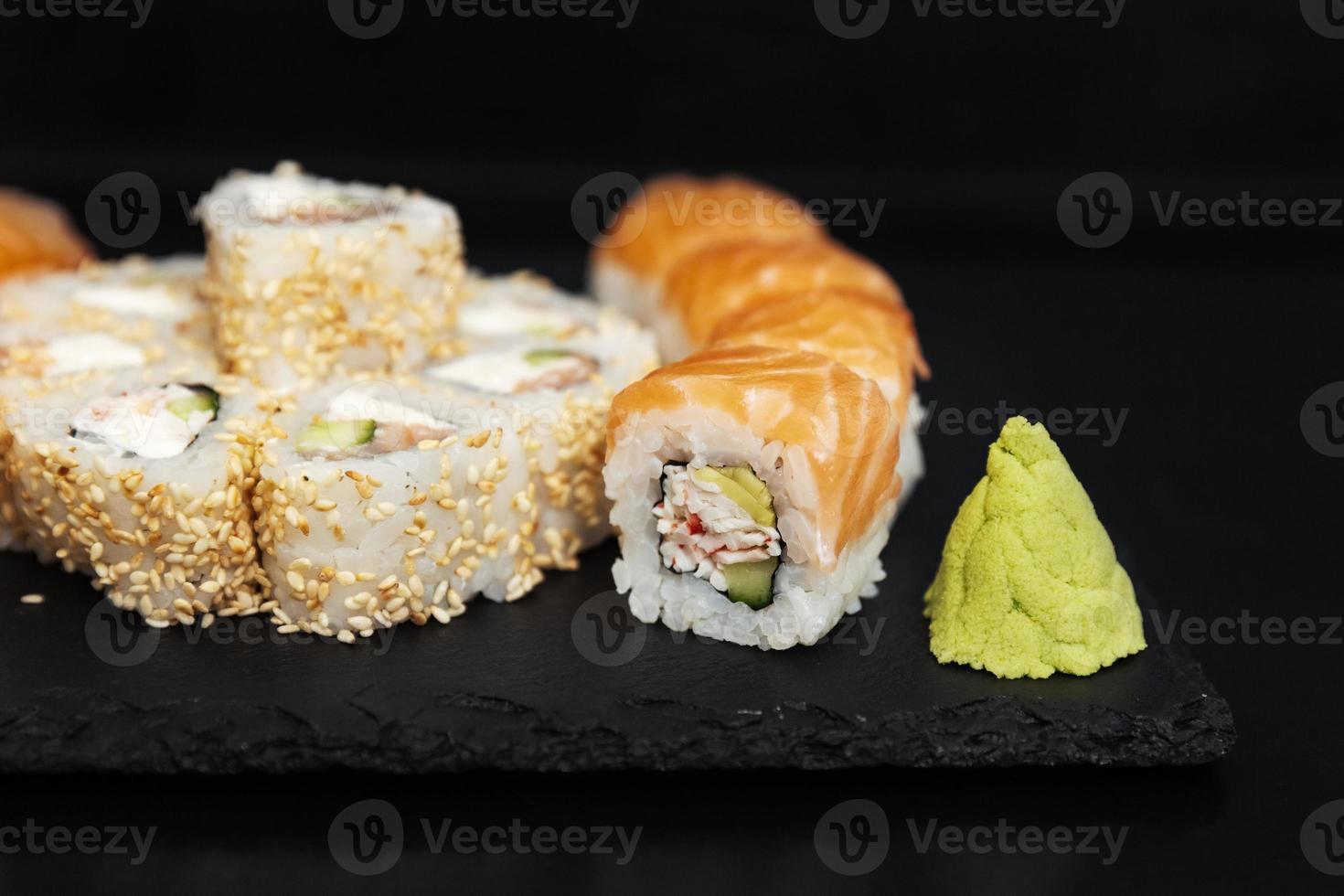 Sushi auf einer Steinplatte mit schwarzem Hintergrund foto