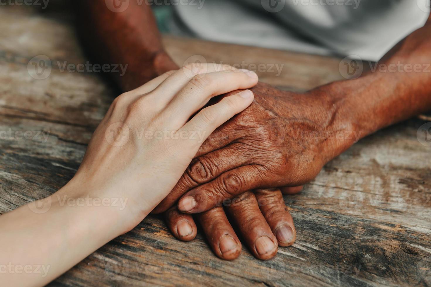 junger Mann, der die Hände einer älteren Frau hält, Nahaufnahme foto