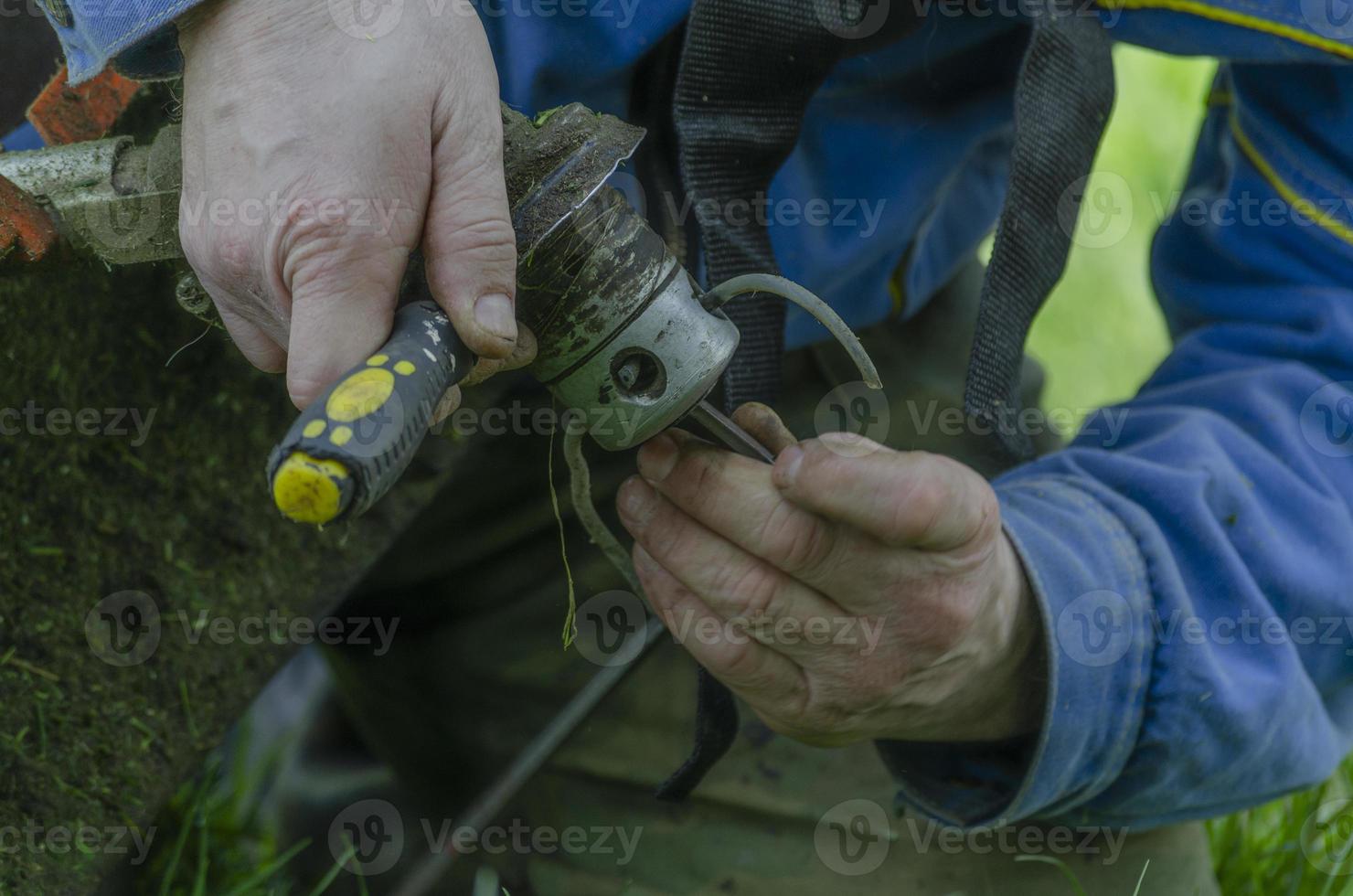 Ersetzen der Angelschnur in einem Rasenmäher durch Werkzeuge foto