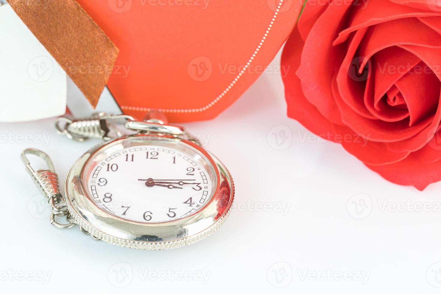 Nahaufnahme Taschenuhr und rote Rosen blühen foto