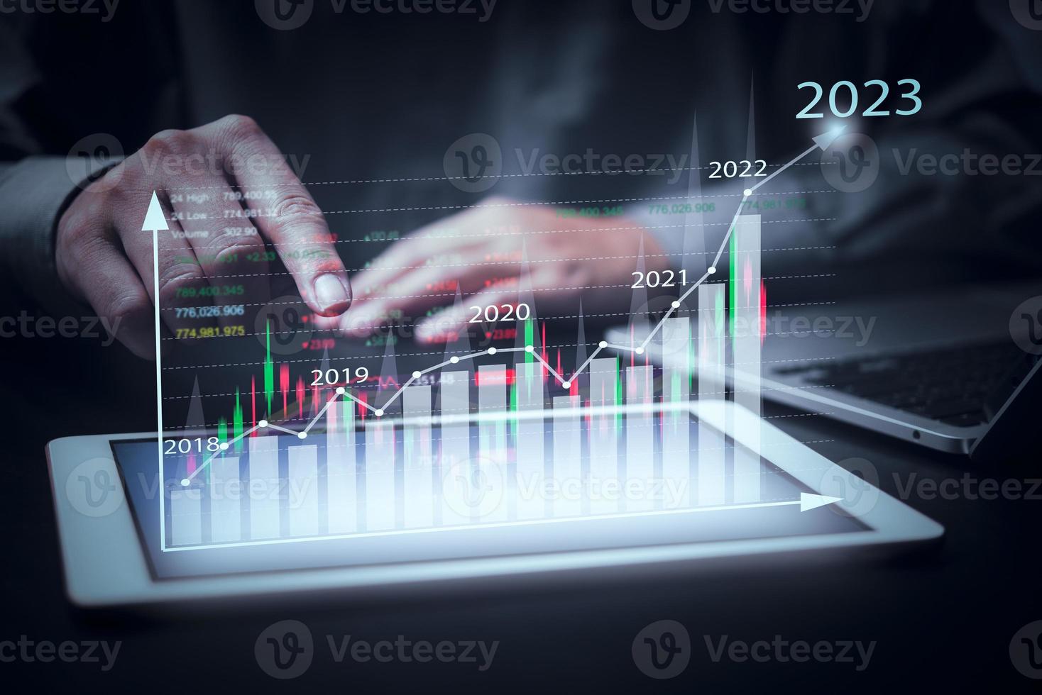 finanzdiagramme und grafikanalysemarketing, die wachsende einnahmen im jahr 2023 zeigen, die über dem digitalen bildschirmtablett schweben, geschäft über strategie für wachstum und erfolg.investitionen in börsenfonds. foto