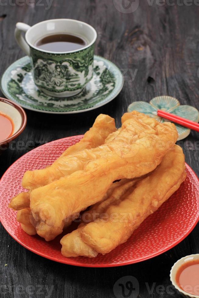 Youtiao oder Cakwe, chinesisches Ölbrot zum Frühstück, serviert mit Tee foto