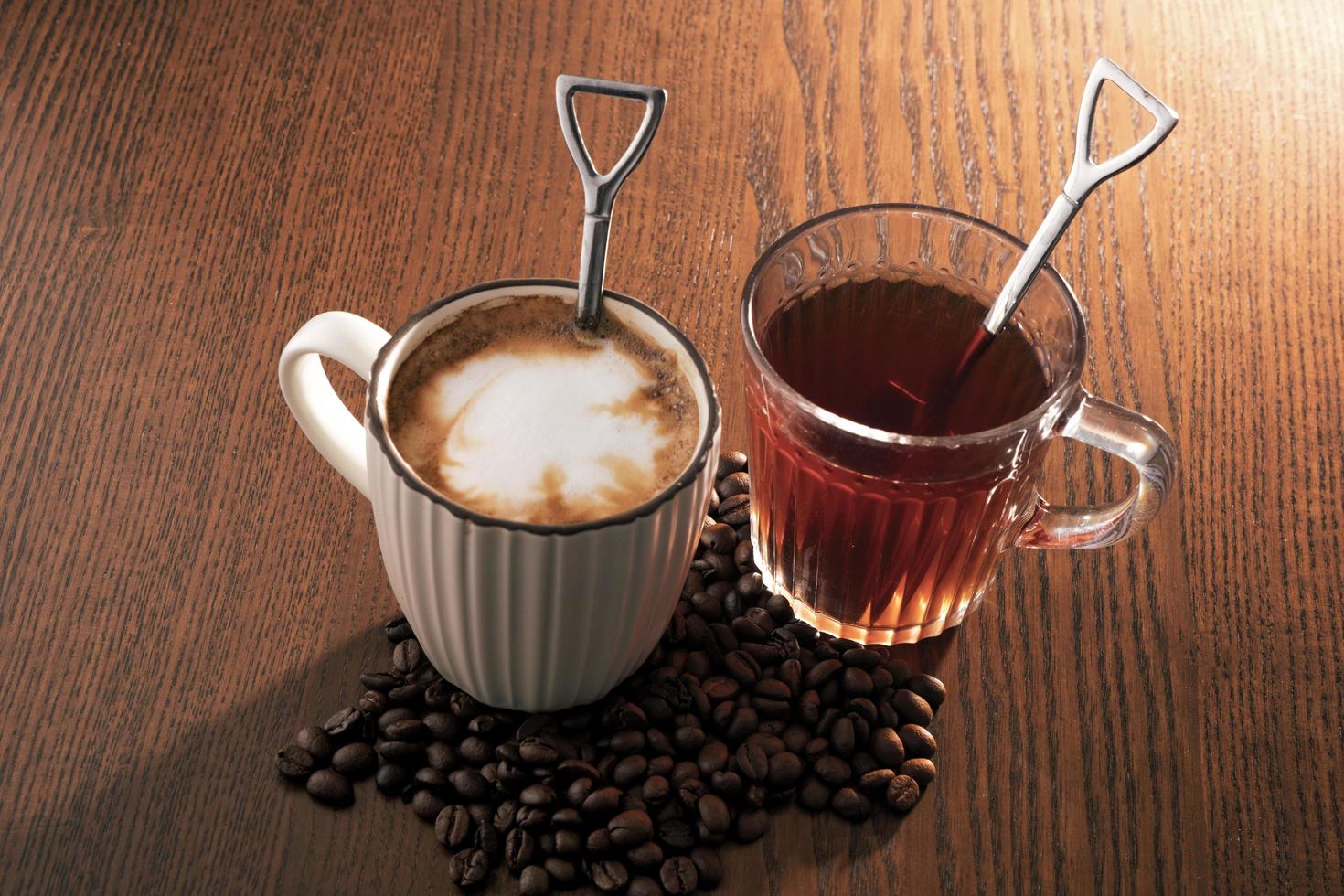 Heißer Kaffee mit Kaffeebohnen und heißem Tee auf Holzhintergrund. foto