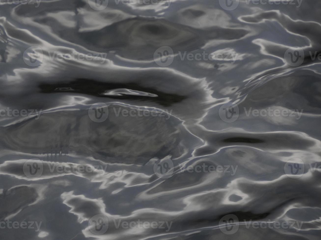 wasserstruktur mit reflektierendem sonnenlicht, das wie flüssiges metall aussieht foto