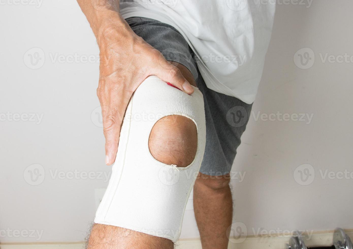 Mann, der einen elastischen Ace-Verband am Knie trägt foto