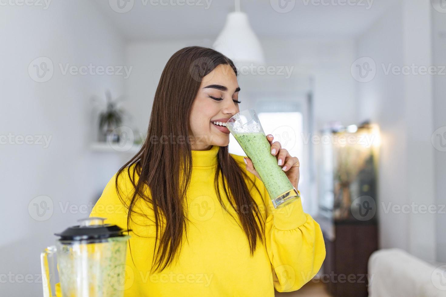 Frau trinkt grünes Detox-Smoothie-Getränk. Fröhliches lächelndes Mädchen mit einem Glas gesundem, frischem Rohgemüse-Smoothie zu Hause. diät ernährungskonzept foto