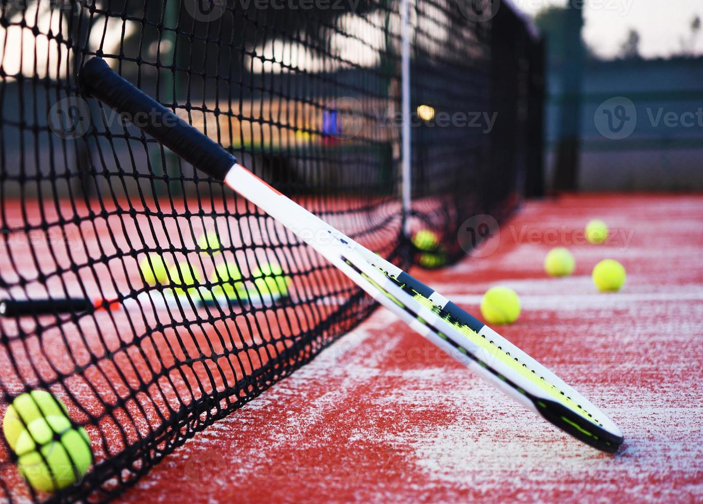 Tennisschläger mit Tennisbällen auf Sandplatz foto