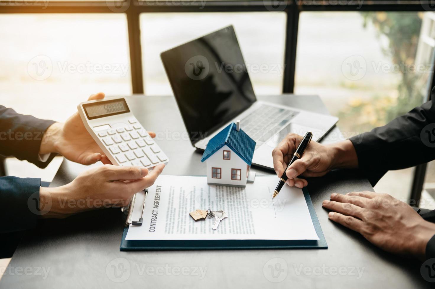 Immobilienmakler-Agent präsentiert und berät den Kunden bei der Entscheidungsfindung, unterzeichnet den Versicherungsvertrag, das Hausmodell, über das Hypothekendarlehensangebot foto