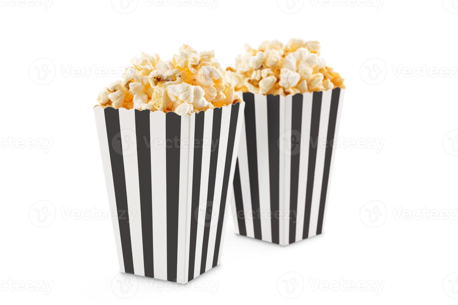 Zwei schwarz-weiß gestreifte Kartoneimer mit leckerem Käse-Popcorn, isoliert auf weißem Hintergrund foto