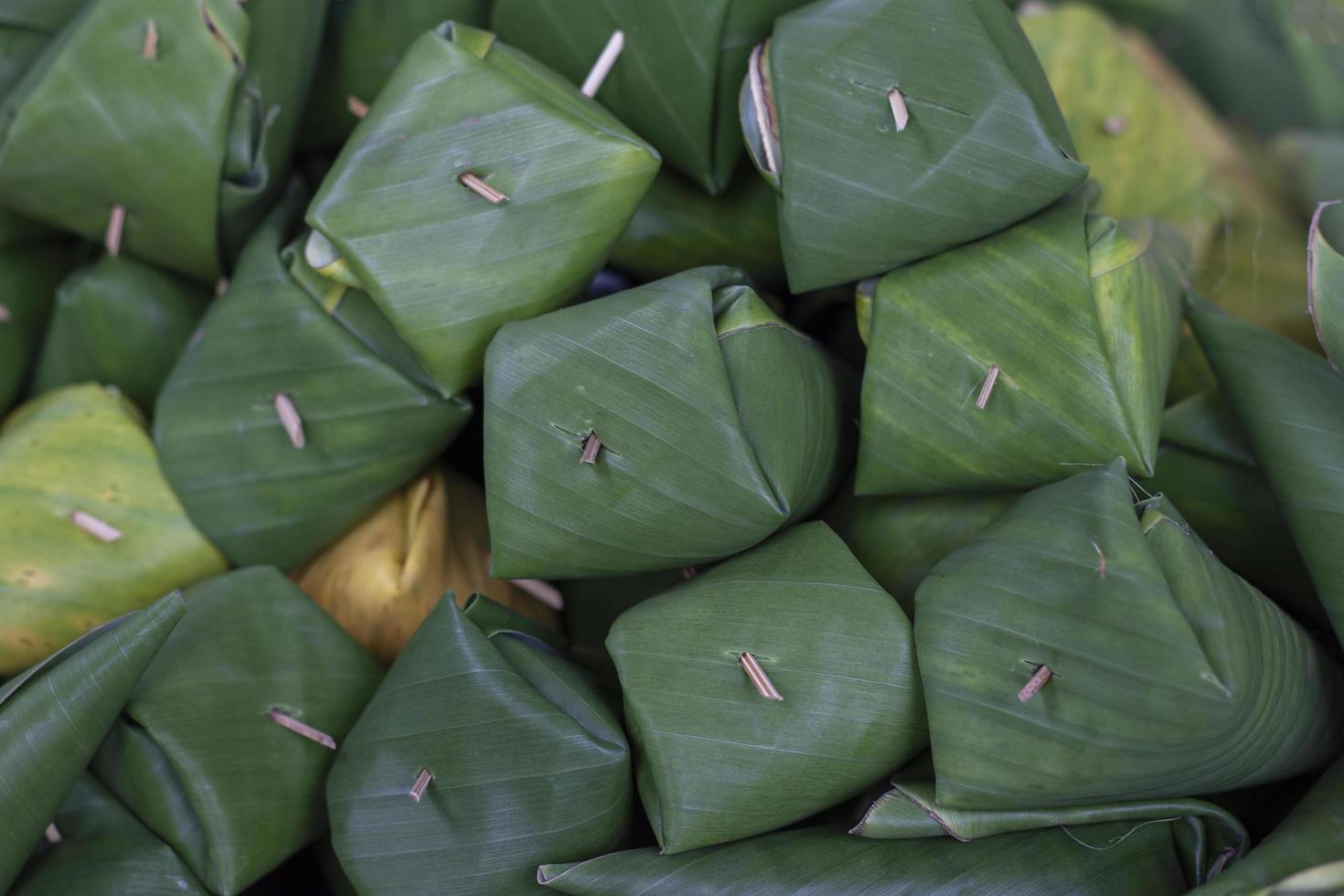 Bereiten Sie sich darauf vor, gegrillten gefüllten Klebreis zuzubereiten, der in Bananenblätter gewickelt ist. Thais nennen ihn Khao Niao Ping. foto