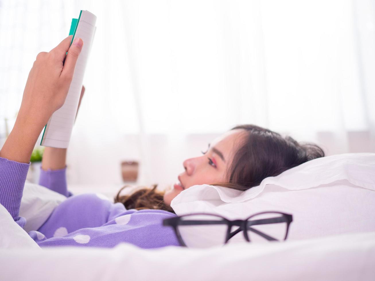 Schöne asiatische Frauen lesen am Wochenende gerne auf dem Bett. Zuhause entspannen foto