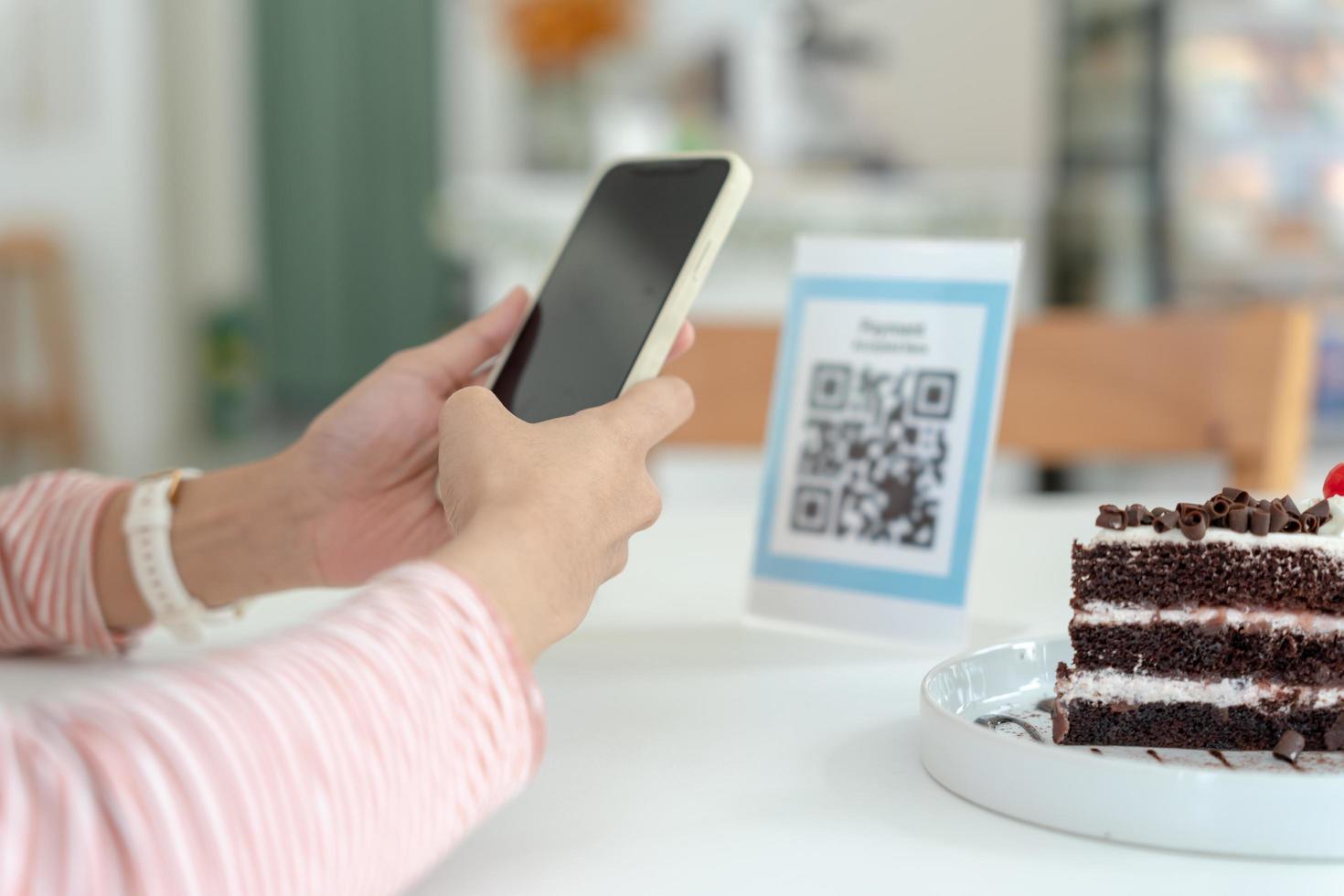 frau verwendet smartphone, um qr-code zu scannen, um im caférestaurant mit einer digitalen zahlung ohne bargeld zu bezahlen. Menü wählen und bestellen Rabatt kumulieren. E-Geldbörse, Technologie, online bezahlen, Kreditkarte, Bank-App. foto