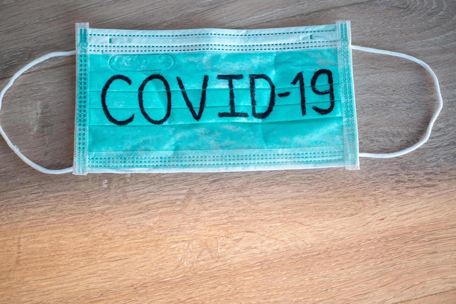 Maske schreibt Covid-19. Die Situation der 2019-ncov-Virusinfektion in Wuhan breitet sich auf der ganzen Welt aus. tödliche Seuche der Welt. das konzept trägt eine maske zum schutz des coronavirus foto