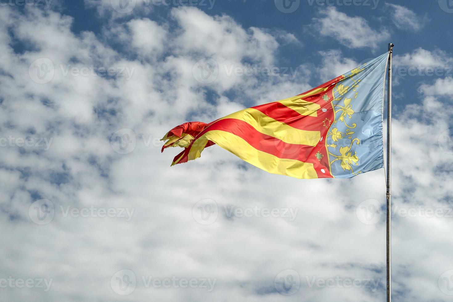 schwenkende valencia-flagge in den blauen himmel foto
