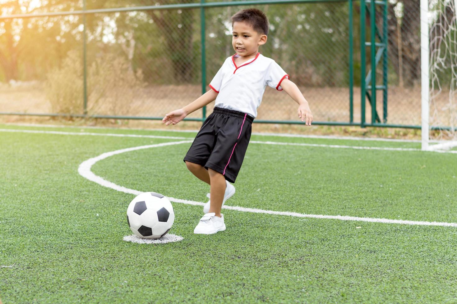 kleiner Junge spielt Fußball foto