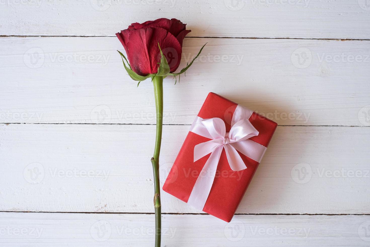 rote Rose und rote Geschenkbox lokalisiert auf weißem hölzernem Hintergrund mit. Valentinstag-Konzept. planung terminplaner, veranstaltung, organisator valentinstag. flache Lage, Draufsicht. foto