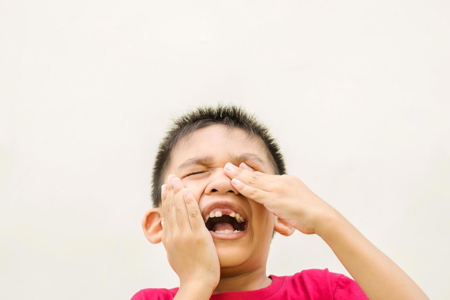 kleiner Junge hält seinen Kopf mit Zahnschmerzen foto