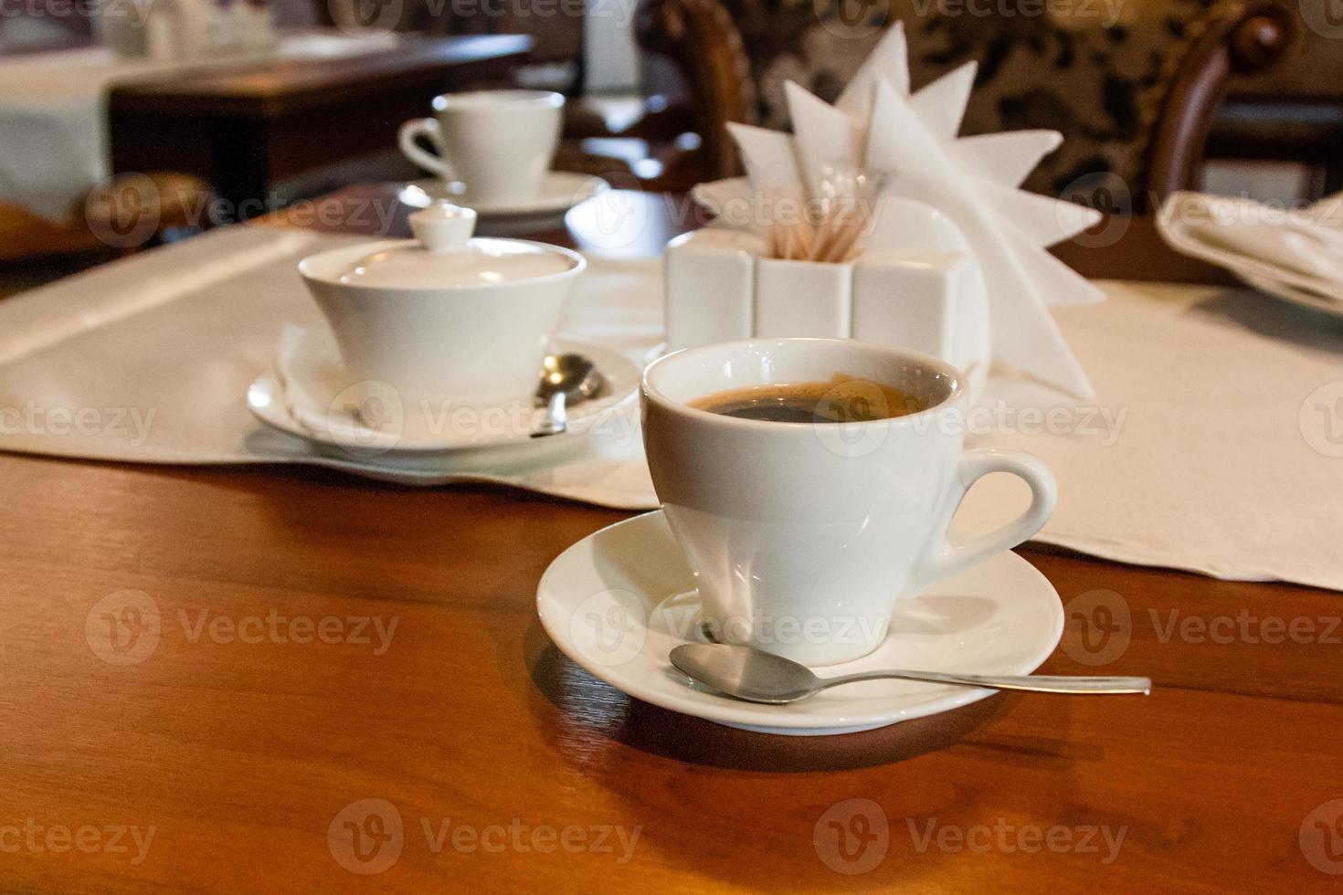 Tasse mit Kaffee auf dem Serviertisch foto