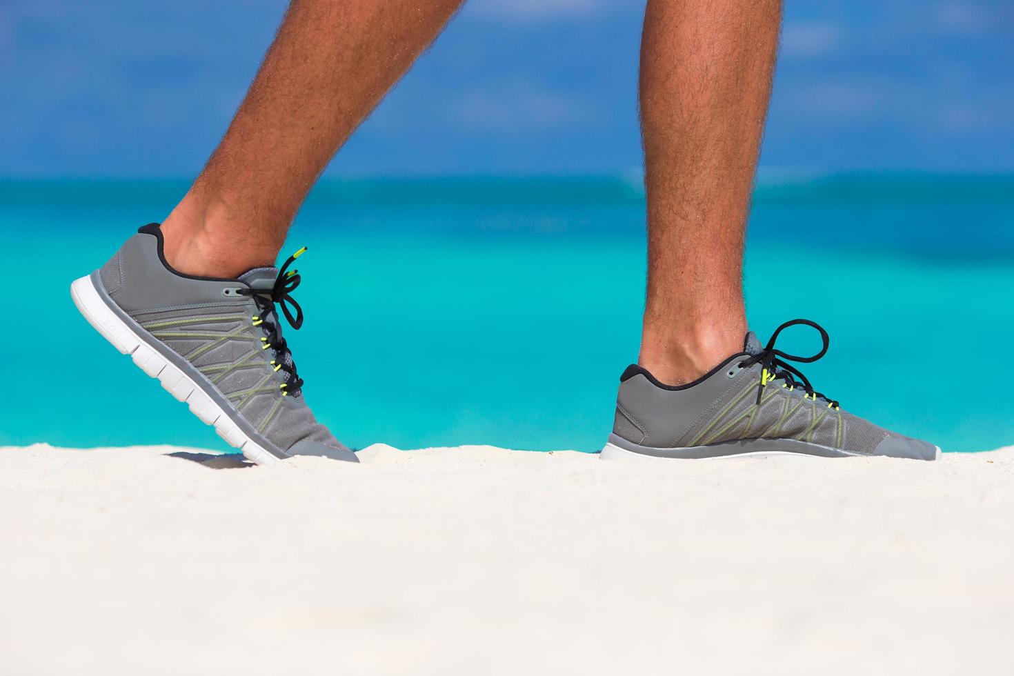 Nahaufnahme einer Person, die Schuhe am Strand trägt foto