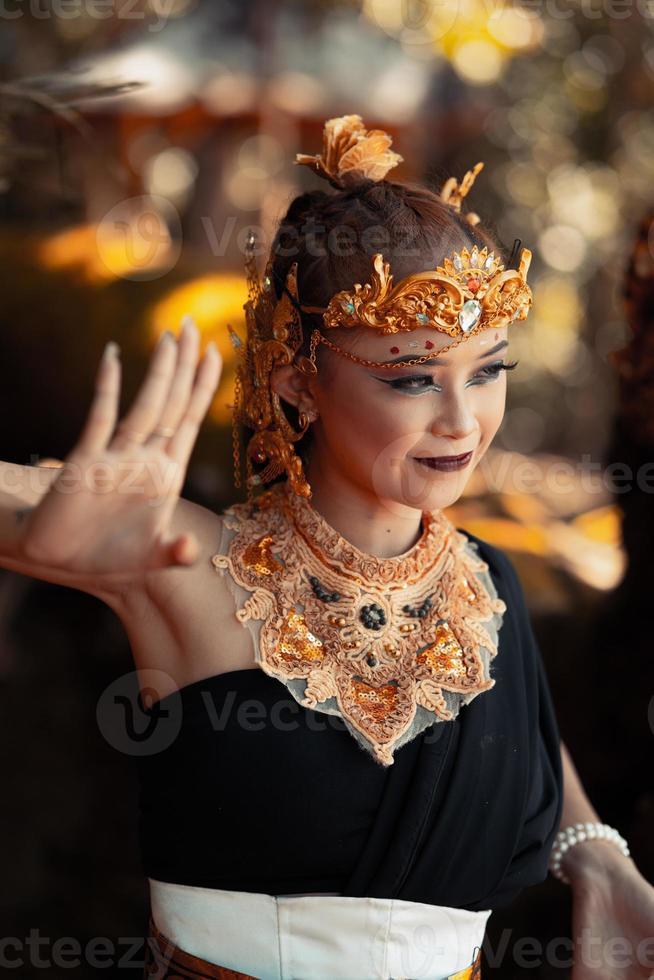 Schöne Stammesfrau, die eine goldene Königinkrone trägt, während sie ein schwarzes Kostüm trägt foto