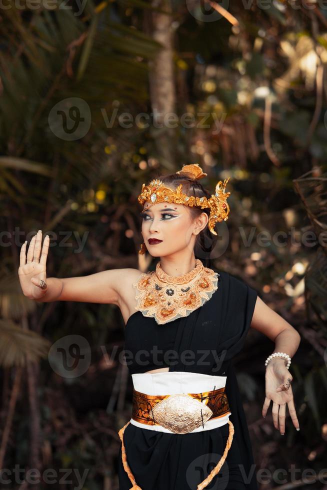 balinesische frau, die eine goldene krone und eine goldene halskette in ihrem make-up mit einem schönen gesicht trägt foto