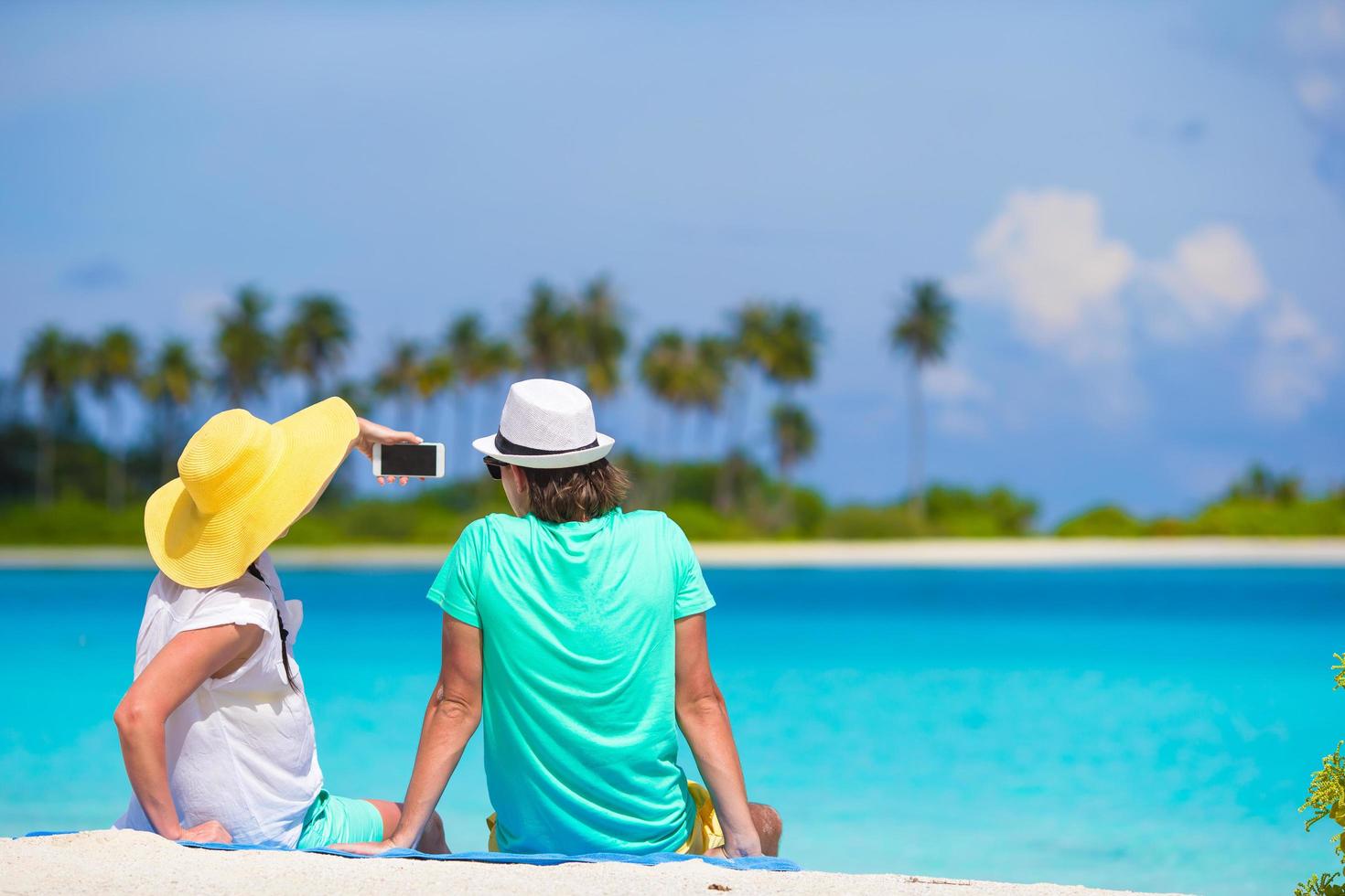 glückliches Paar, das ein Selfie am Strand nimmt foto