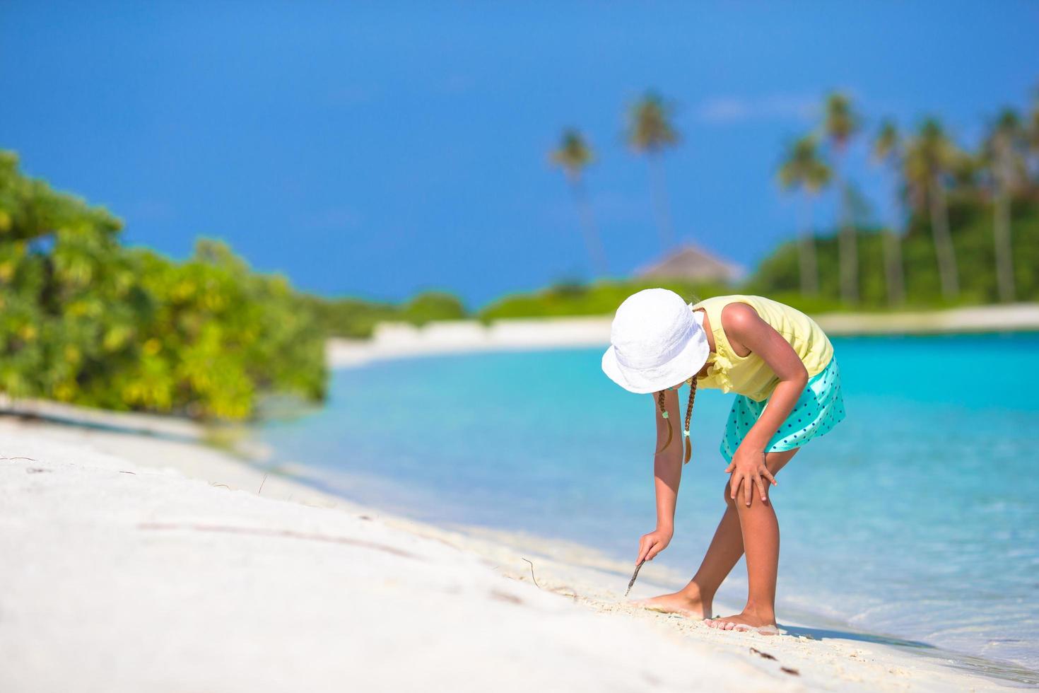 Mädchen spielt im weißen Sand foto