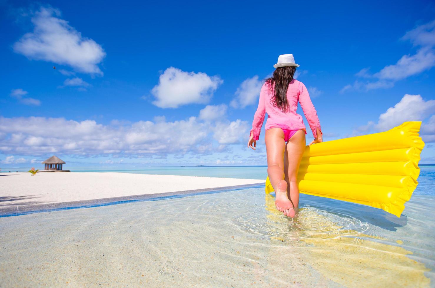 Frau, die im Wasser am Strand geht foto