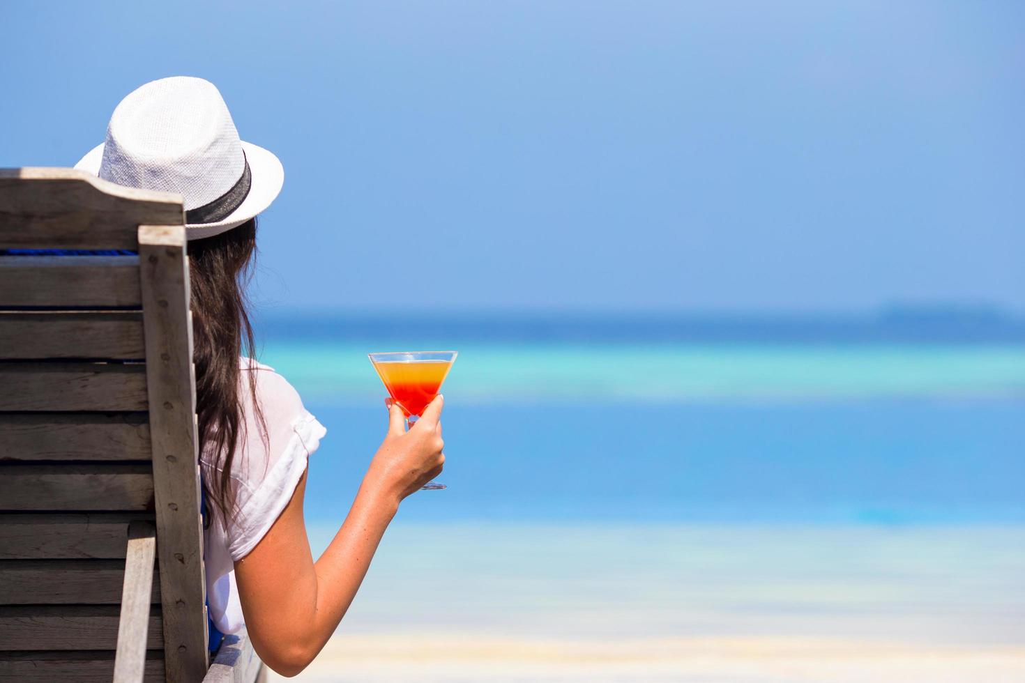 Frau, die ein Cocktailglas nahe Schwimmbad hält foto