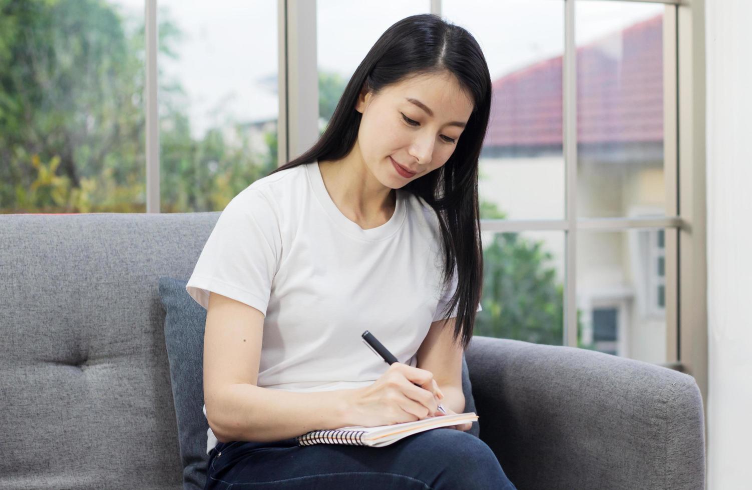 Frau Journaling auf dem Sofa foto