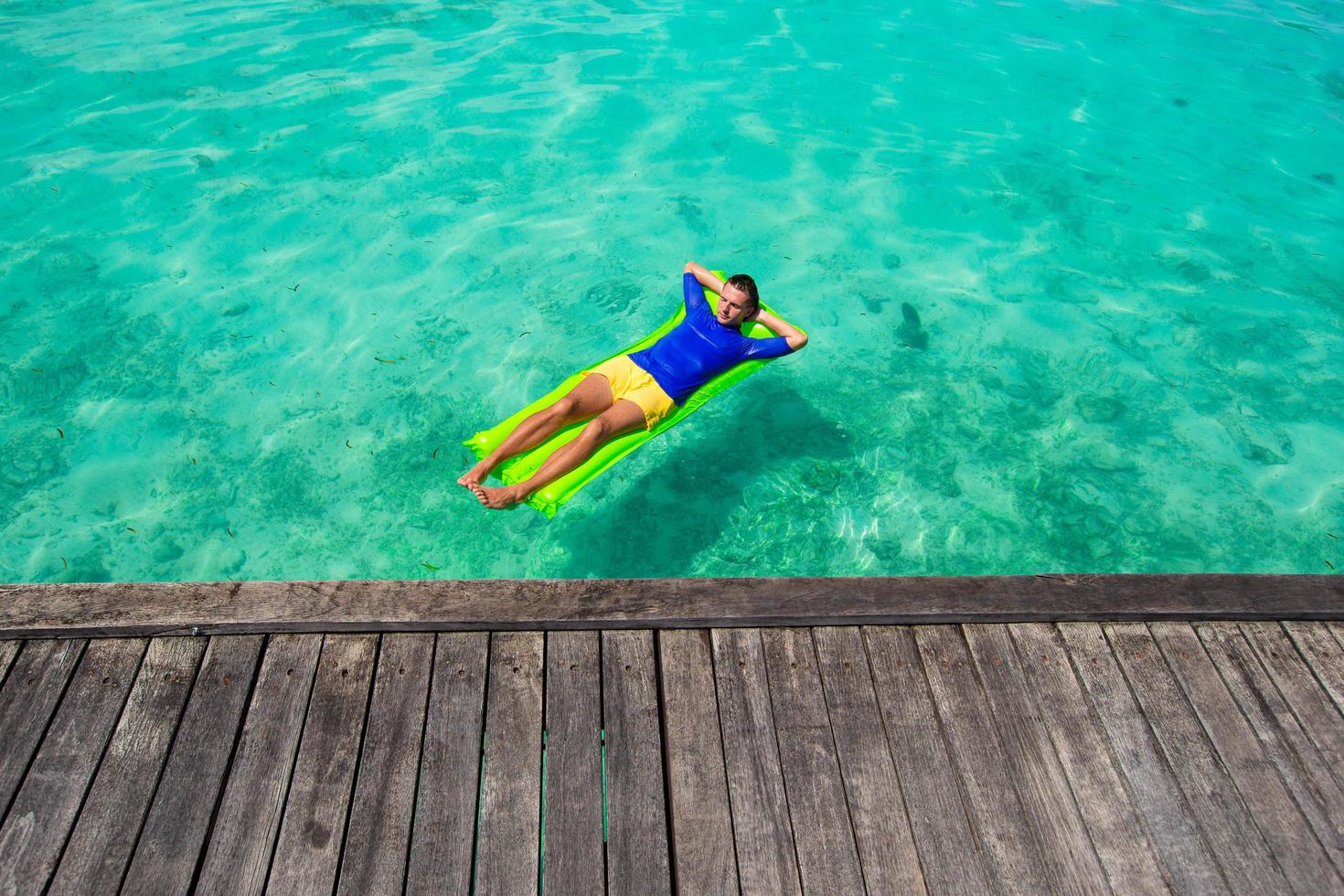 Mann, der sich auf einem Floatie im Ozean entspannt foto