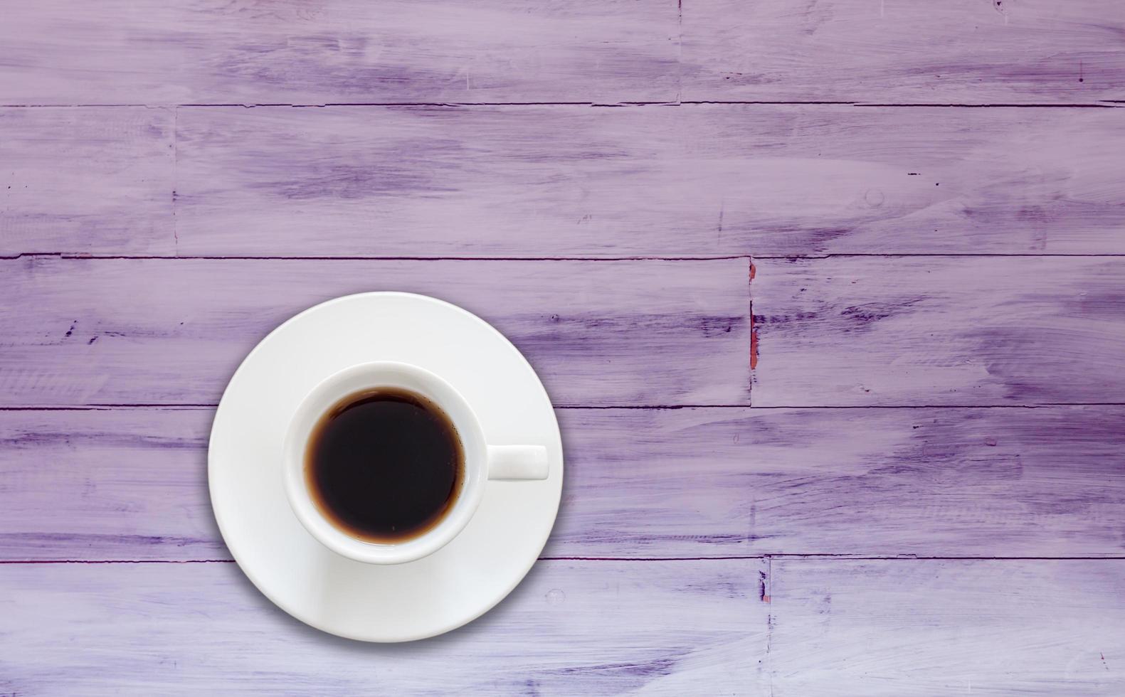 Draufsicht der Kaffeetasse auf einem lila hölzernen Hintergrund foto