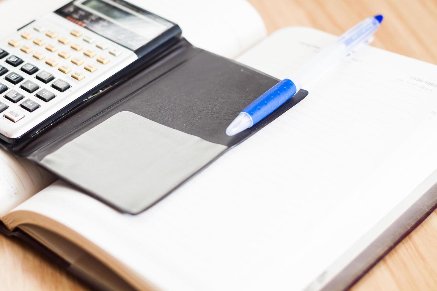 Taschenrechner mit einem Notizbuch und einem Stift foto