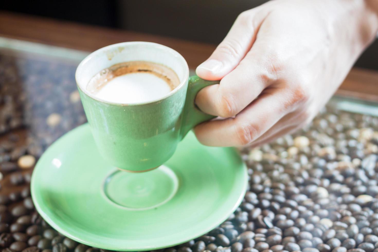 Hand hält eine Kaffeetasse foto