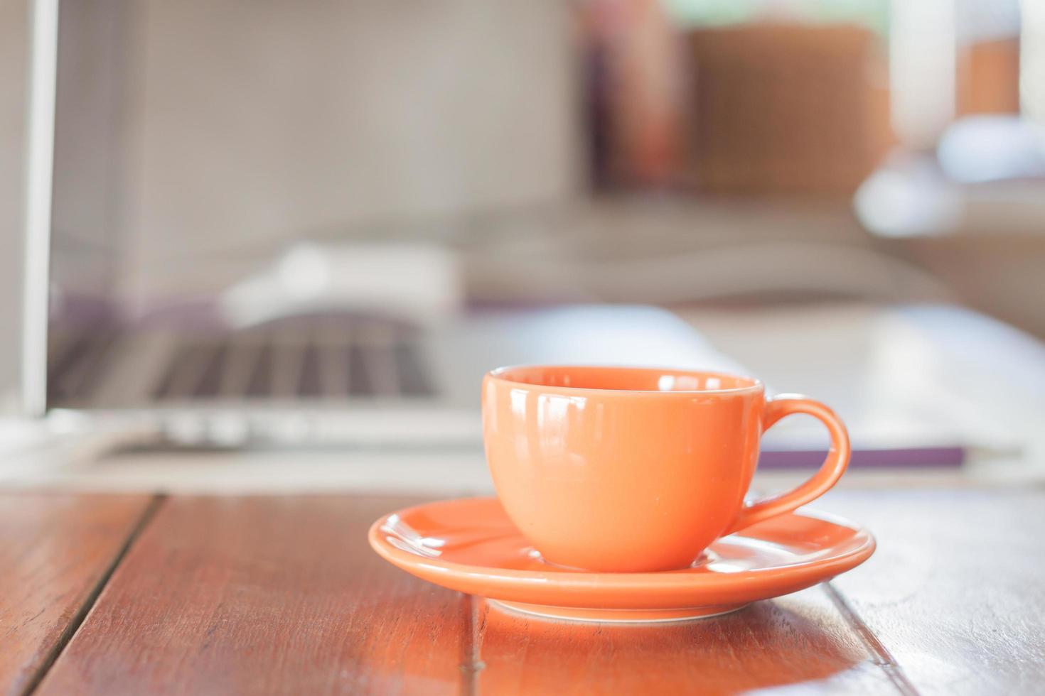 orange Kaffeetasse auf einem Arbeitsplatz foto