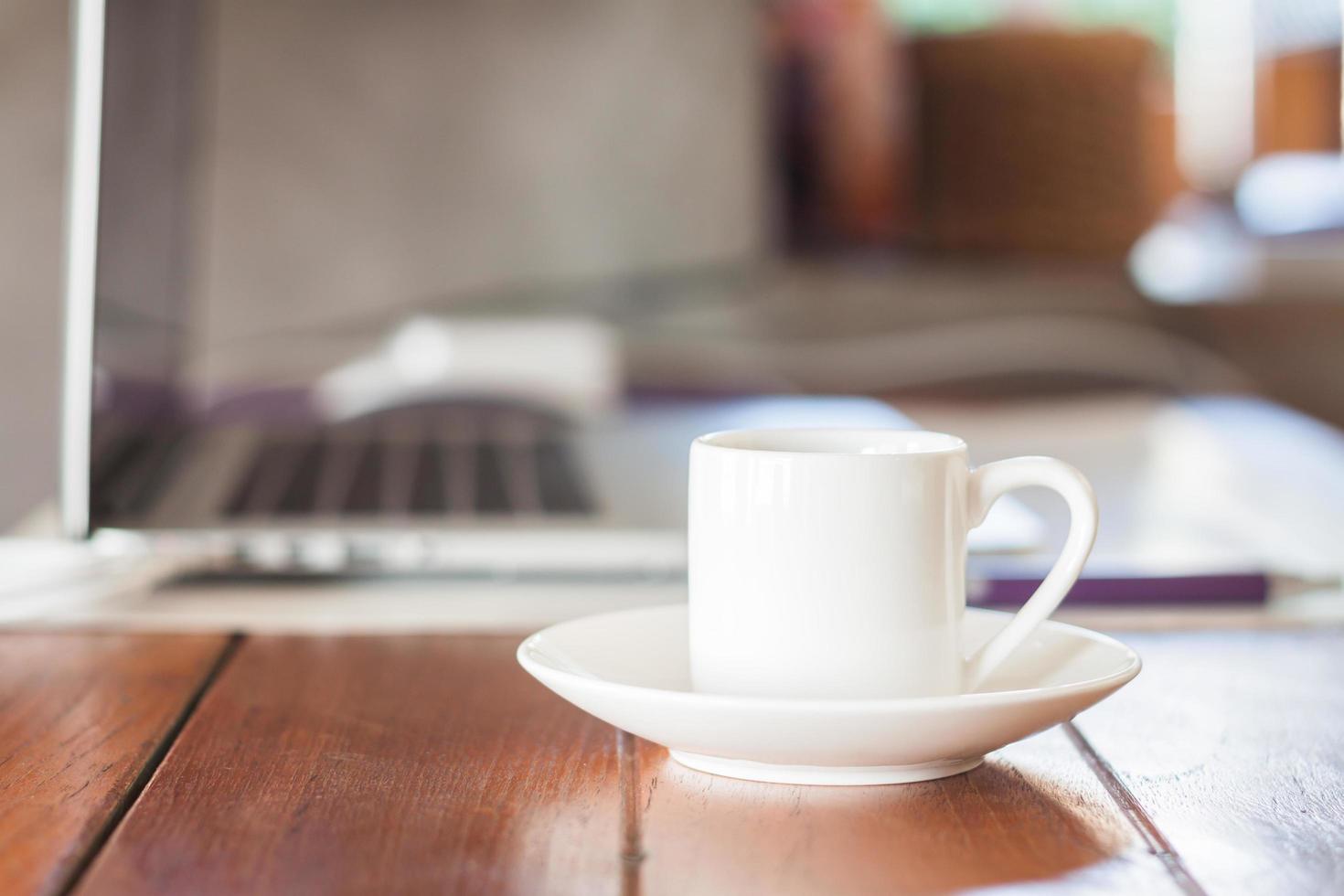 Mini weiße Kaffeetasse am Arbeitsplatz foto