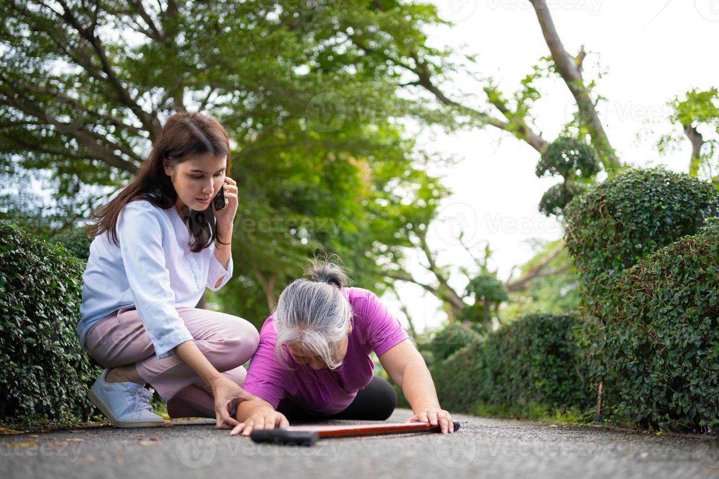 asiatische Seniorin fiel auf den liegenden Boden, weil Ohnmacht und Gliederschwäche und Schmerzen durch einen Unfall auftraten und die Frau kam, um zu helfen und den Notruf zu rufen. konzept der alten versicherung und gesundheitsversorgung foto