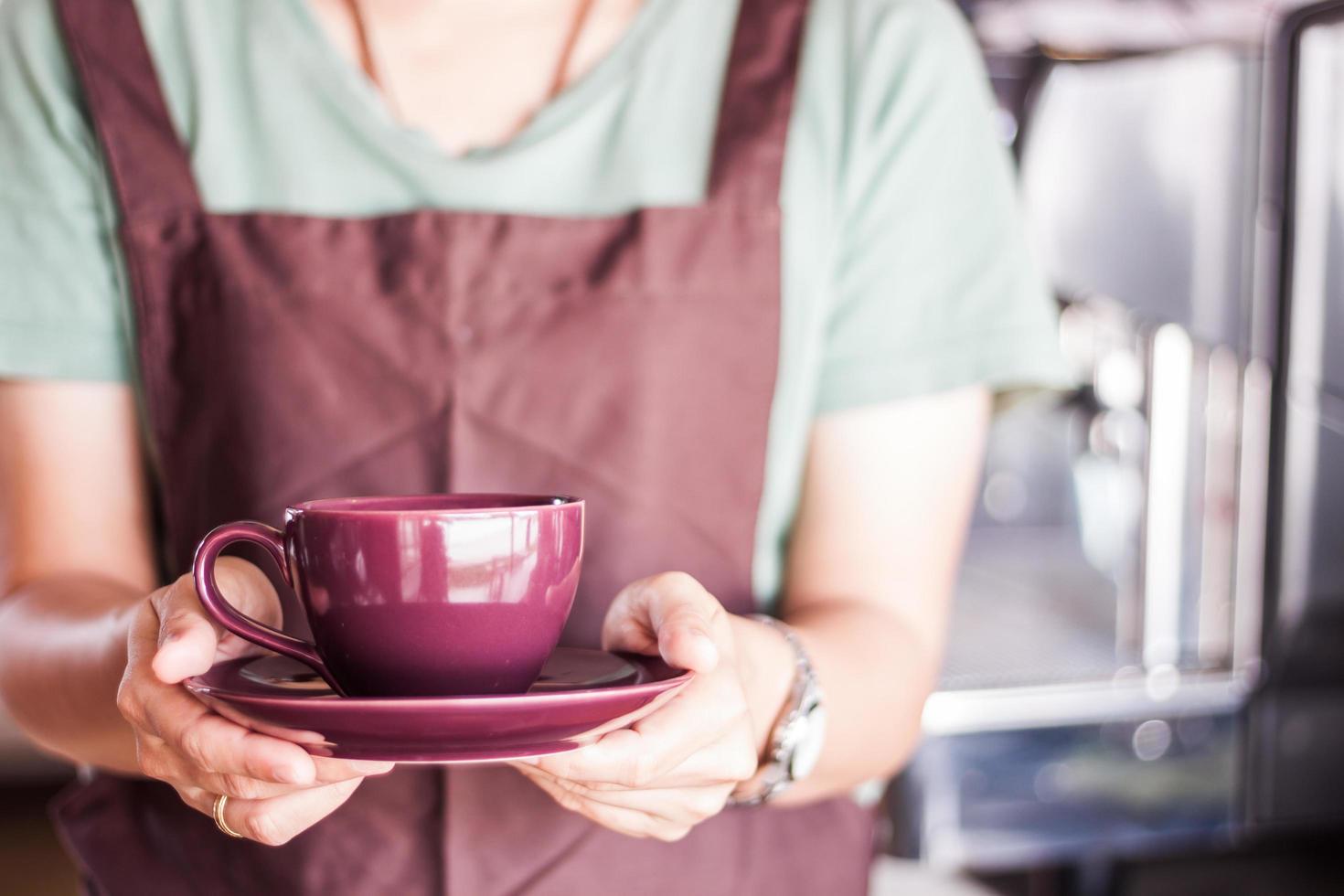 Barista hält eine lila Tasse foto