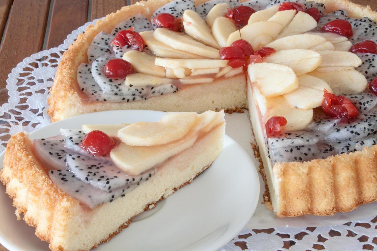 Kuchen mit Drachenfrüchten, Äpfeln und Kirschen foto