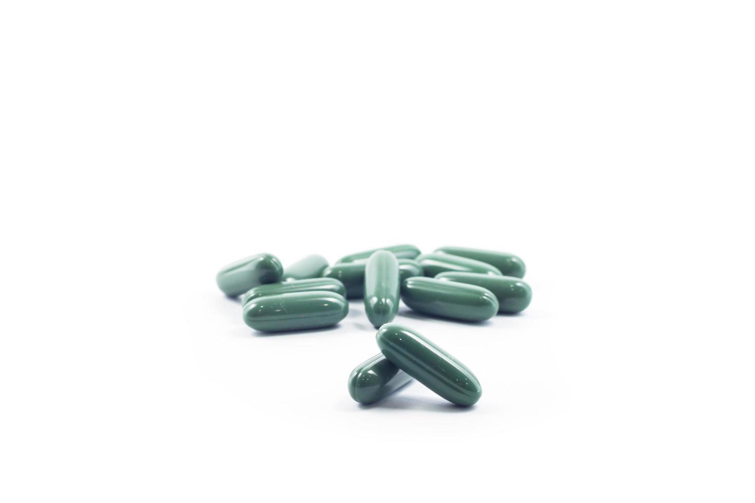 Stapel von grünen Pillen auf einem weißen Hintergrund foto