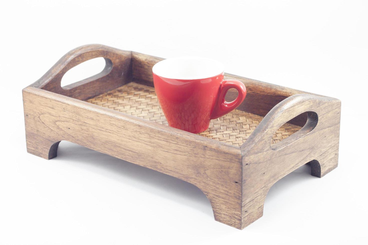 rote Kaffeetasse auf einem Holztablett foto