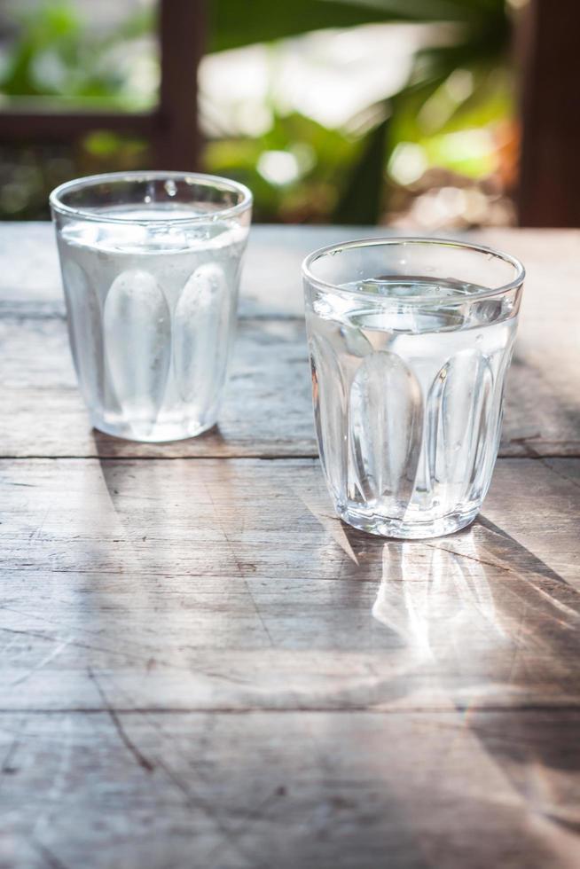 Gläser kaltes Wasser auf einem Holztisch foto