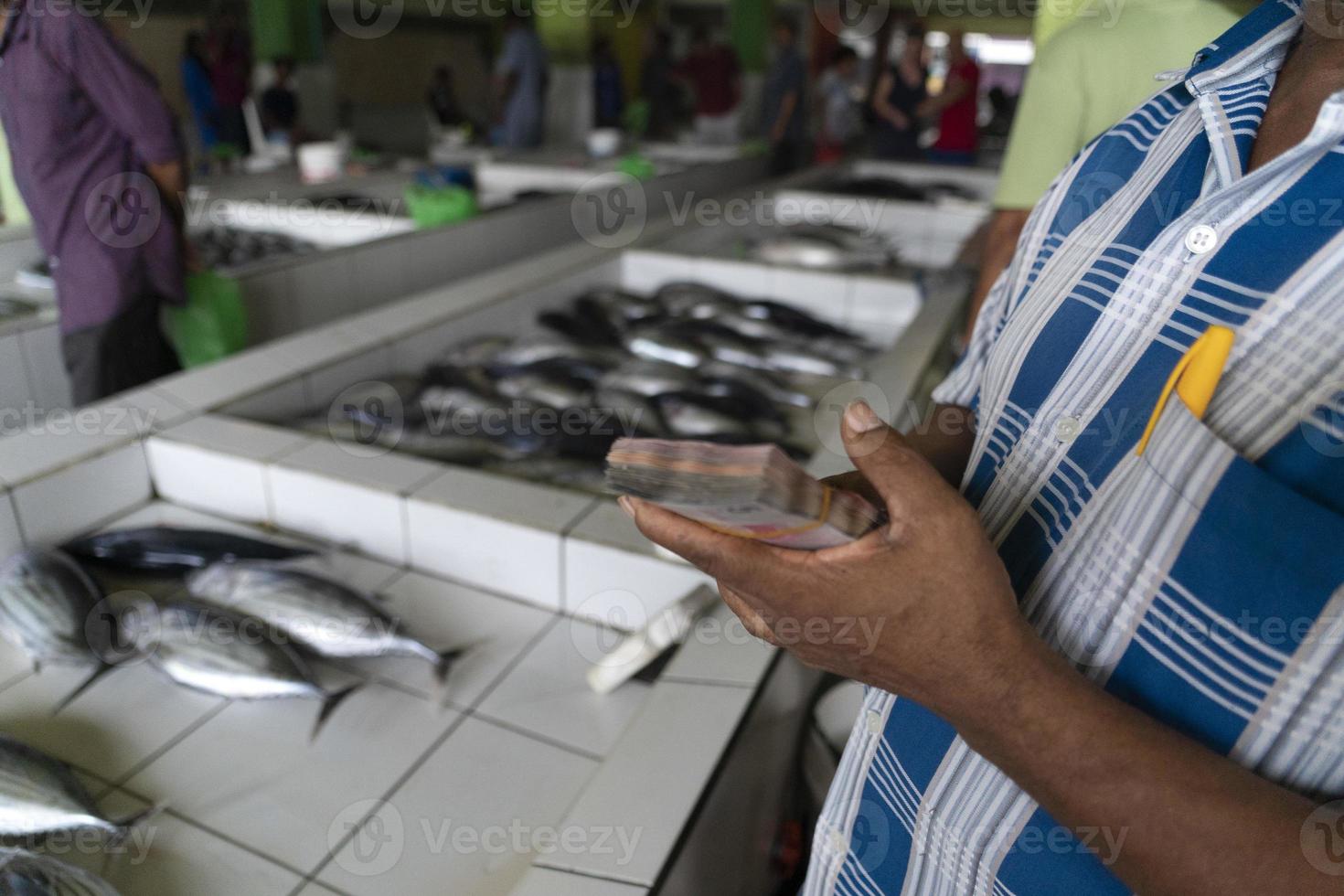 männliche malediven leute, die auf dem fischmarkt kaufen foto