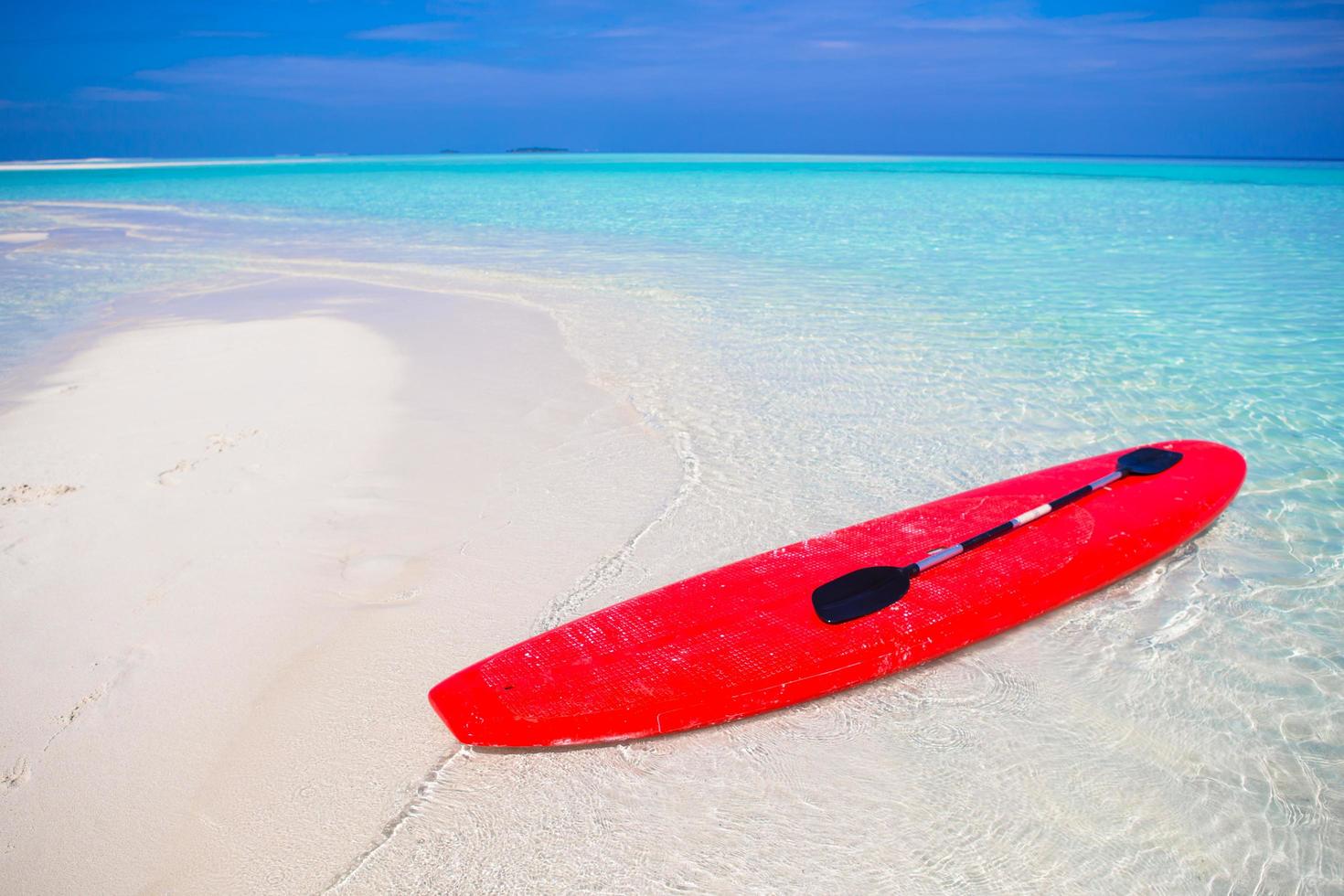 rotes Surfbrett am Strand foto